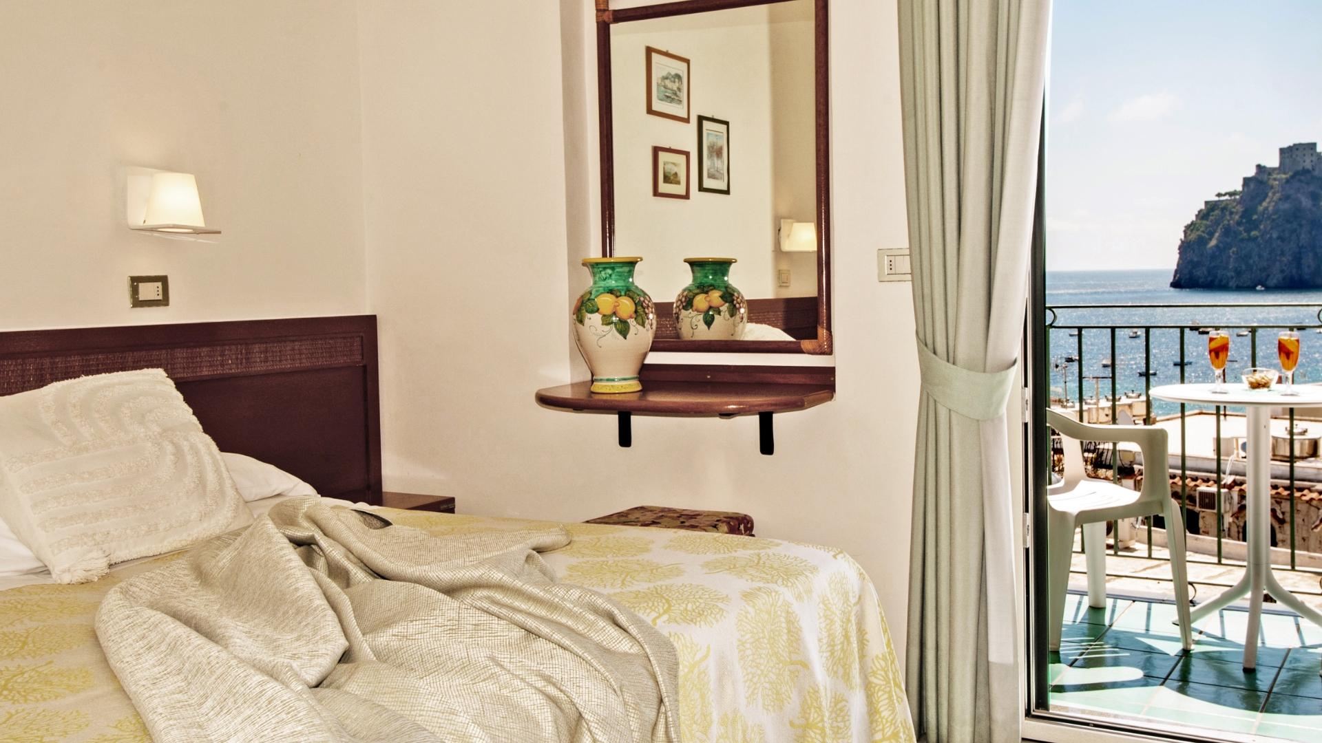 Camera elegante con vista mare, balcone soleggiato, atmosfera rilassante e accogliente.